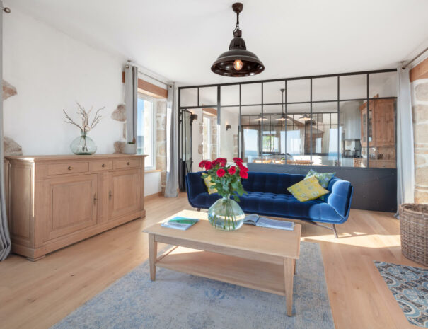 Gîte vue mer en Bretagne, un grand salon dans l'ancienne salle de vigie du Sémaphore avec vue panoramique sur la mer et de superbes sofa Roche-Bobois